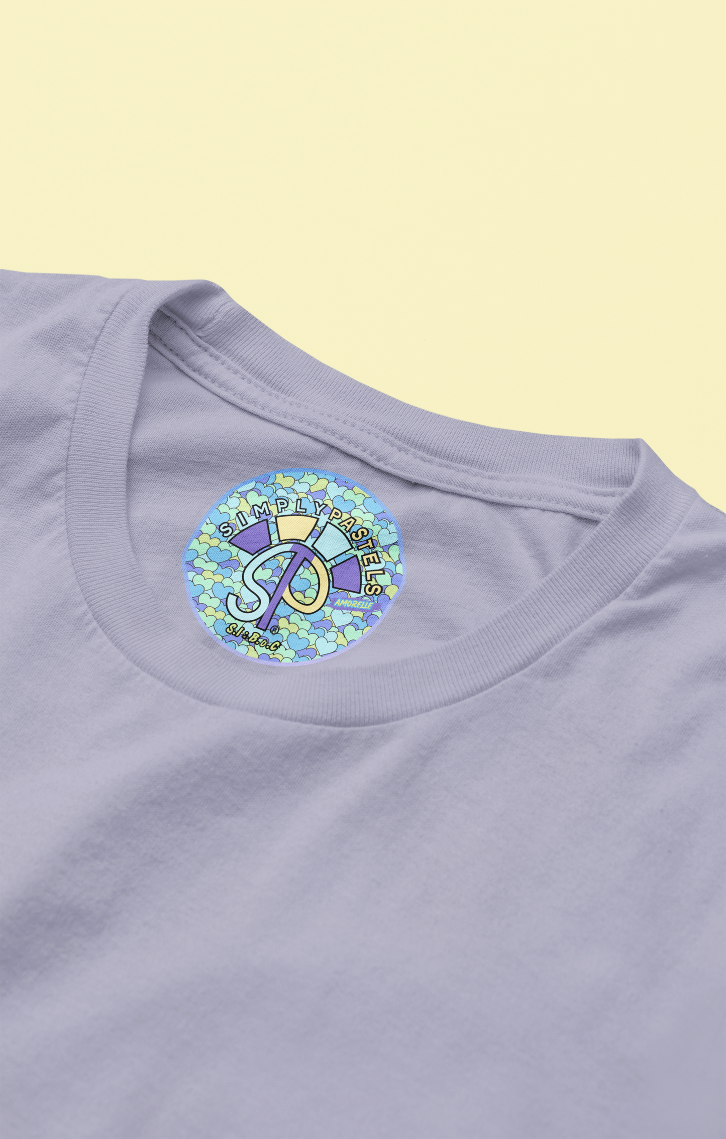 Label view of the lavender Amorelle organic cotton t-shirt with a pastel graphic design, from Simply Pastels, a UK-based premium ethical clothing brand.