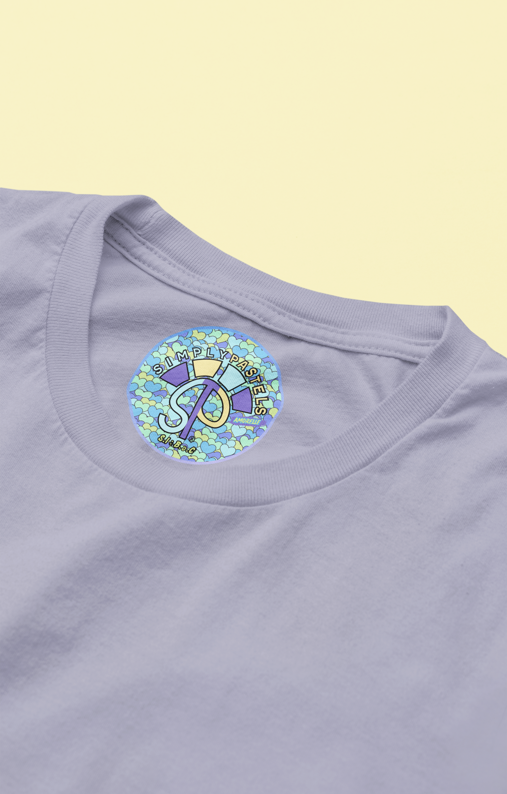 Label view of the lavender Amorelle organic cotton t-shirt with a pastel graphic design, from Simply Pastels, a UK-based premium ethical clothing brand.
