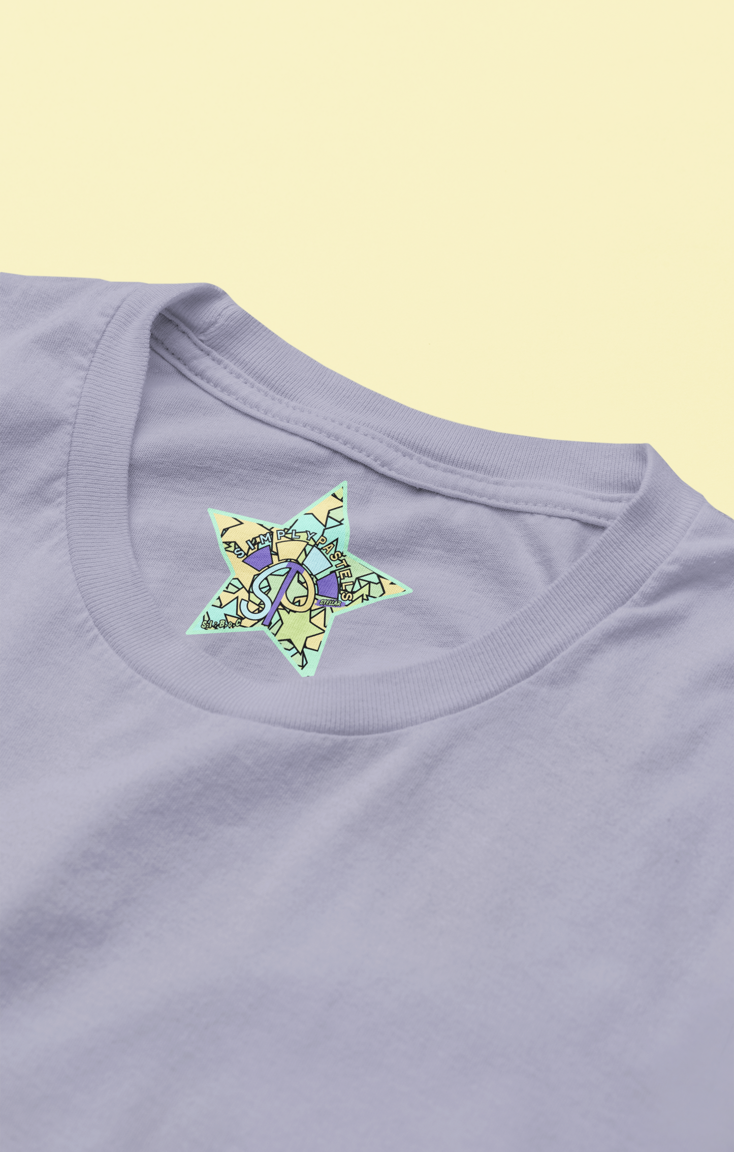 Label view of the lavender Stellar organic cotton t-shirt with a pastel graphic design, from Simply Pastels, a UK-based premium ethical clothing brand.