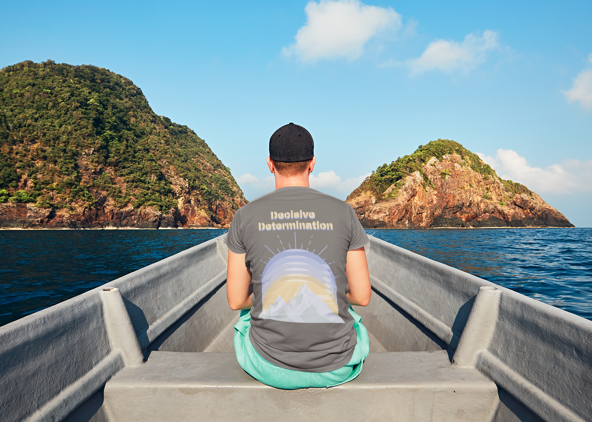 Back view of a man wearing Simply Pastels Season 1:BoC Heather Grey Decisive Determination pastel graphic t-Shirt, sitting in a boat and facing a mountainous landscape.