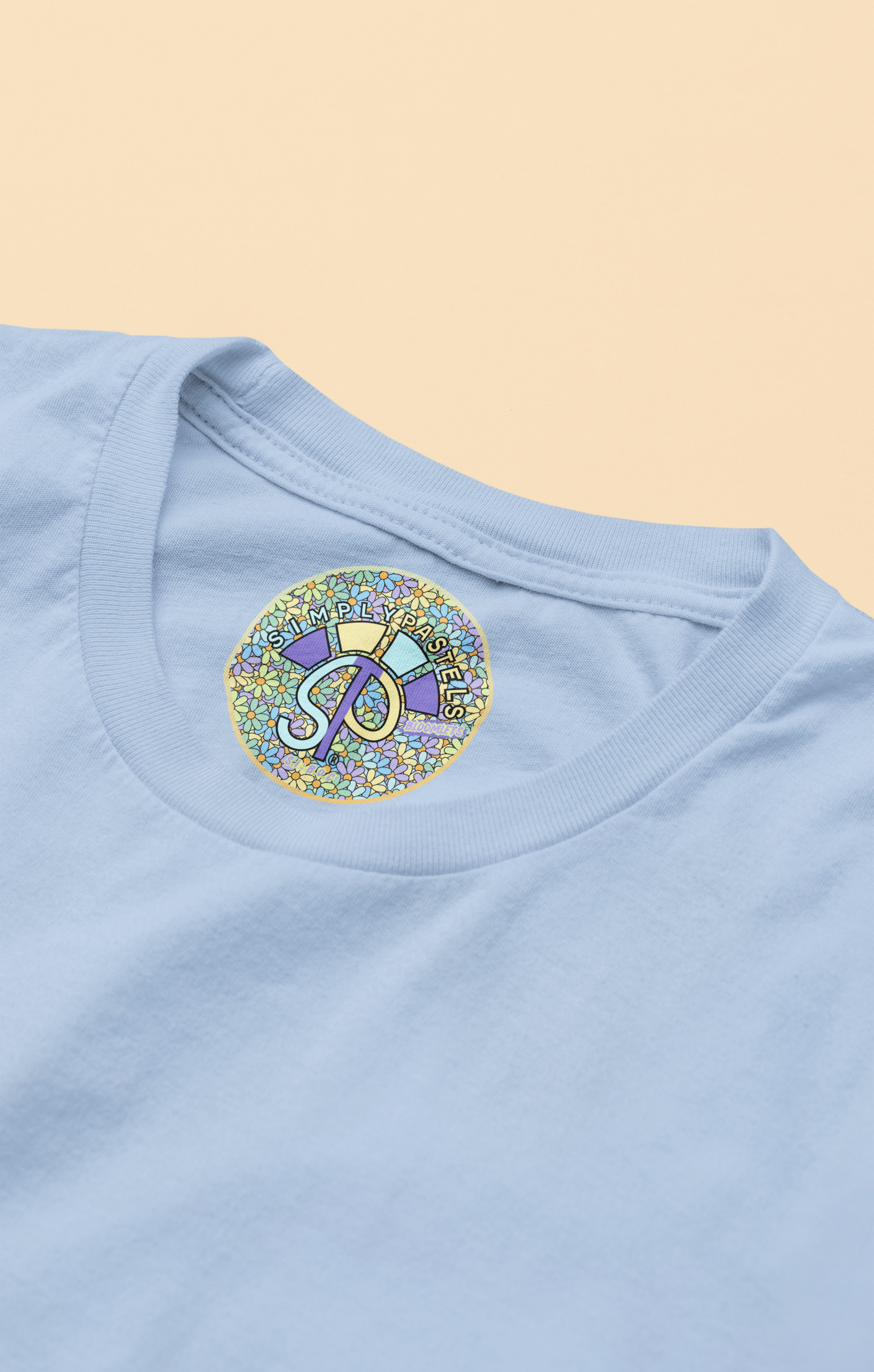 Label view of the blue soul Bloomlets organic cotton t-shirt with a pastel graphic design, from Simply Pastels, a UK-based premium ethical clothing brand.