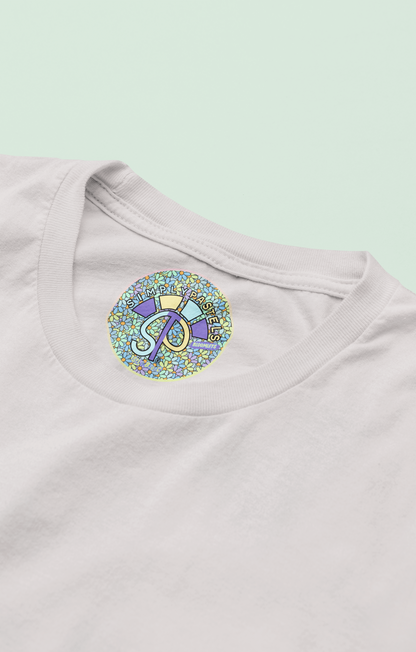 Label view of the off-white Bloomlets organic cotton t-shirt with a pastel graphic design, from Simply Pastels, a UK-based premium ethical clothing brand.
