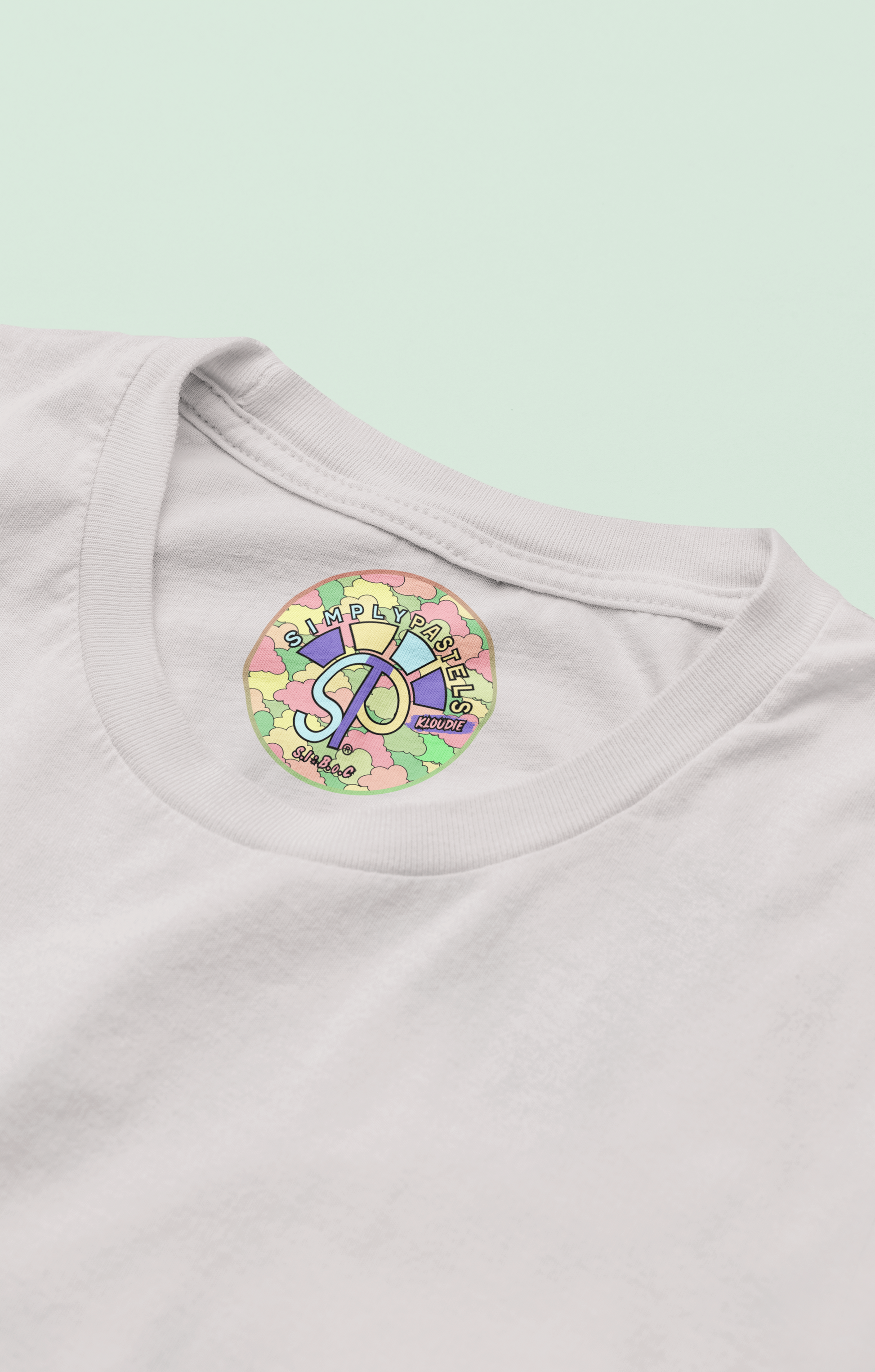 Label view of the off-white Kloudie organic cotton t-shirt with a pastel graphic design, from Simply Pastels, a UK-based premium ethical clothing brand.